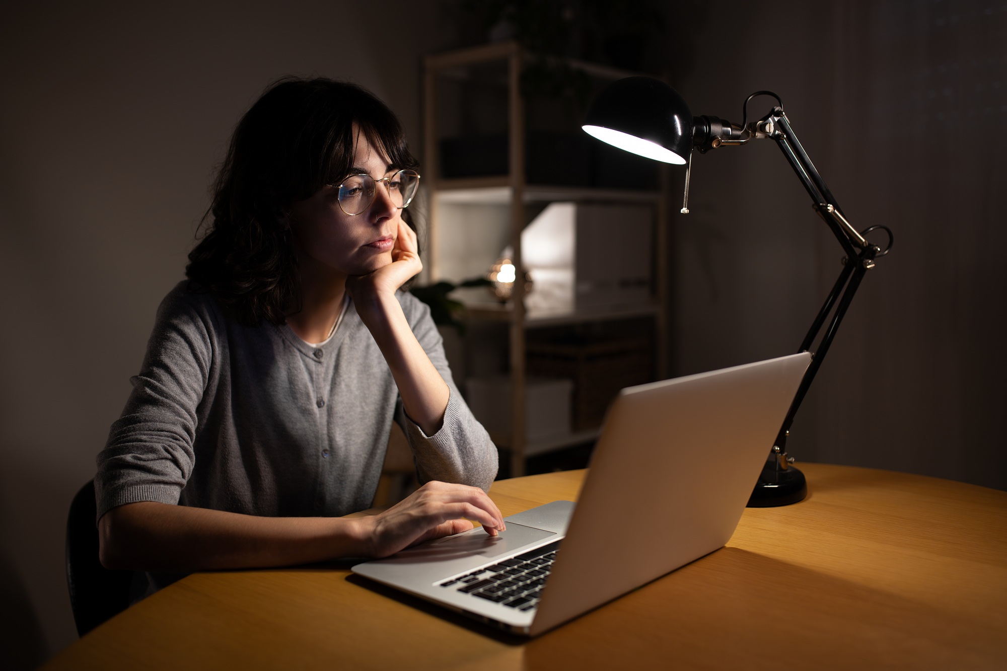 Young woman working late at night with laptop at home.